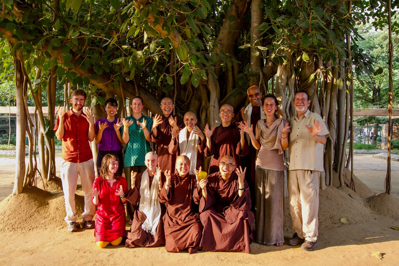 photo of a group of Plum Village monastics and lay friends standing in front of a tree in India