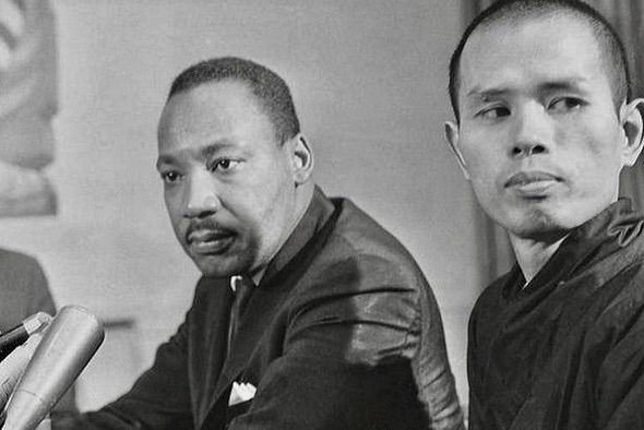 a black and white photo of Thich Nhat Hanh and Dr. Martin Luther King, Jr. sitting in front of microphones, taken in 1966