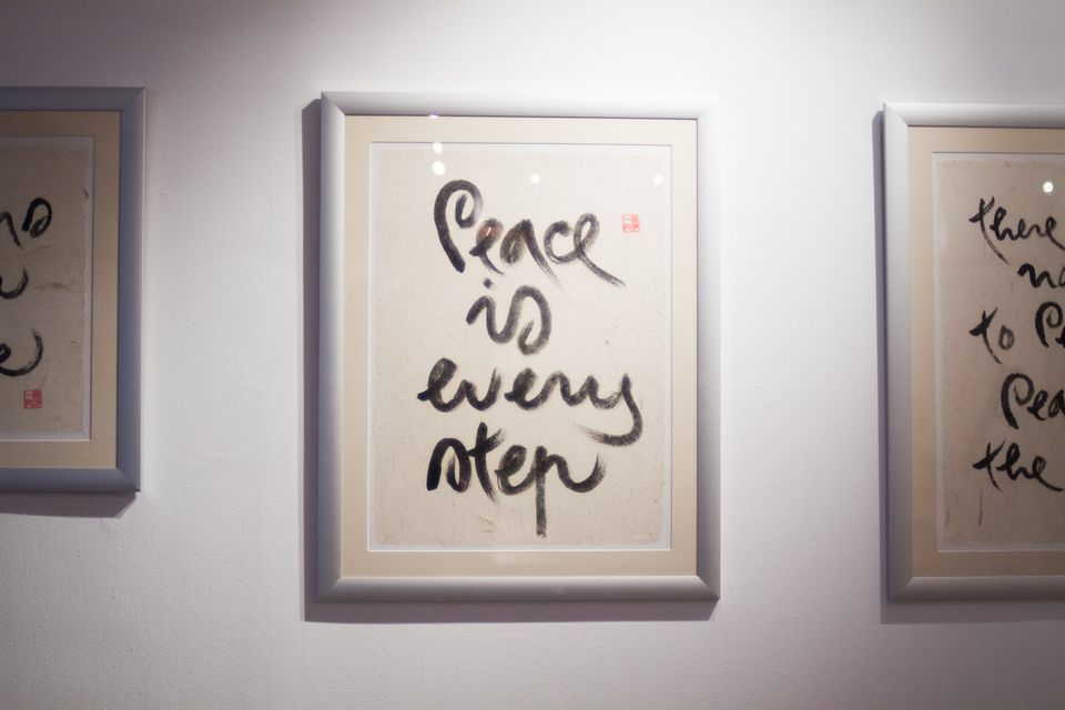 Image of calligraphy hanging in a frame on a wall. The calligraphy reads, "Peace Is Every Step."